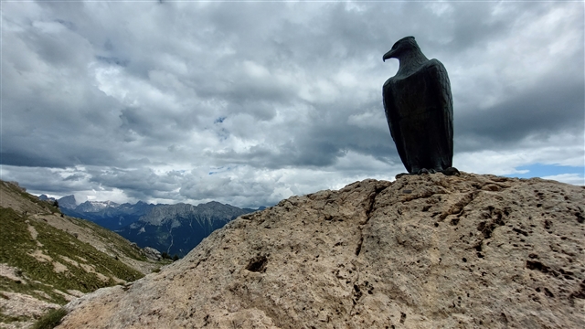 Scendendo dal Roda Di Vael ad un certo punto tra le nubi ed i monti si staglia un'aquila di bronzo.